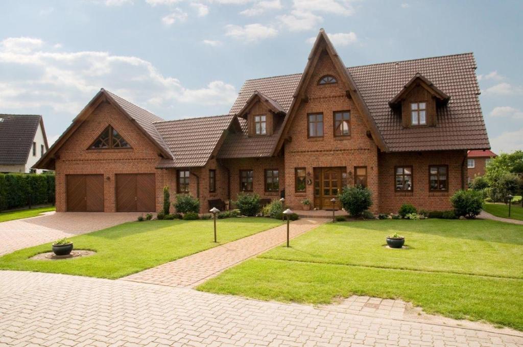 een groot huis met een groen gazon ervoor bij Ferienwohnungen Holzmann in Buchholz (Aller)