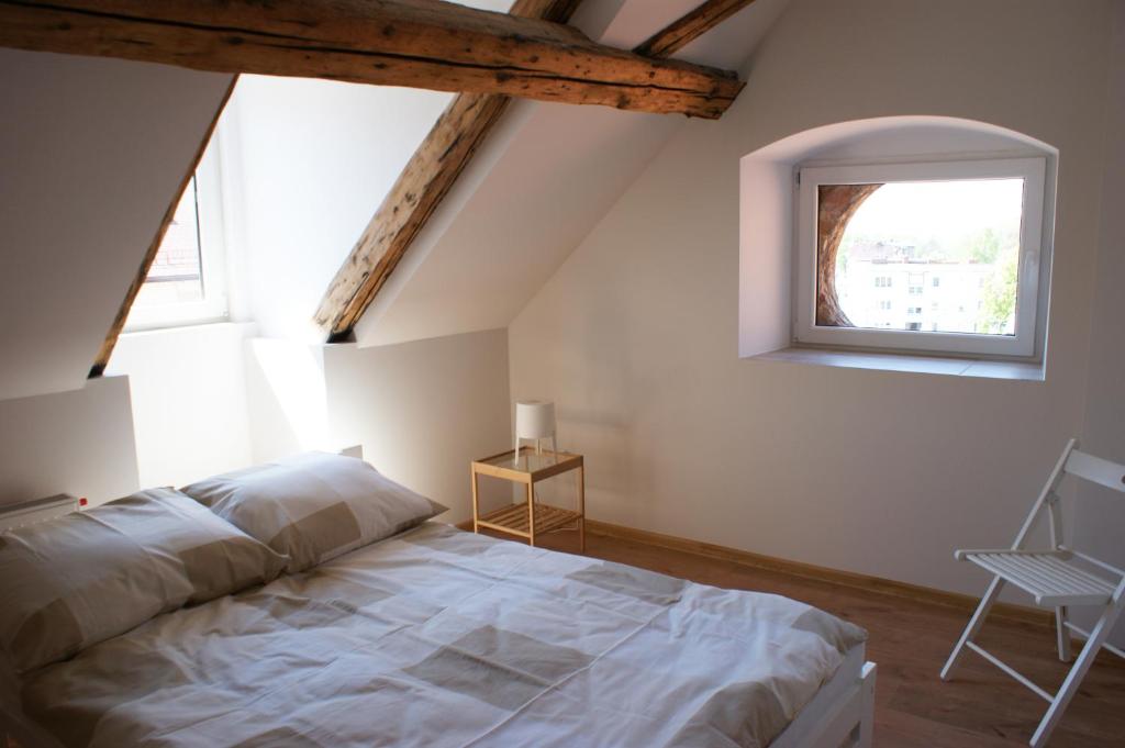 a bedroom with a bed and a window and a chair at Majówka w Karkonoszach II in Kowary