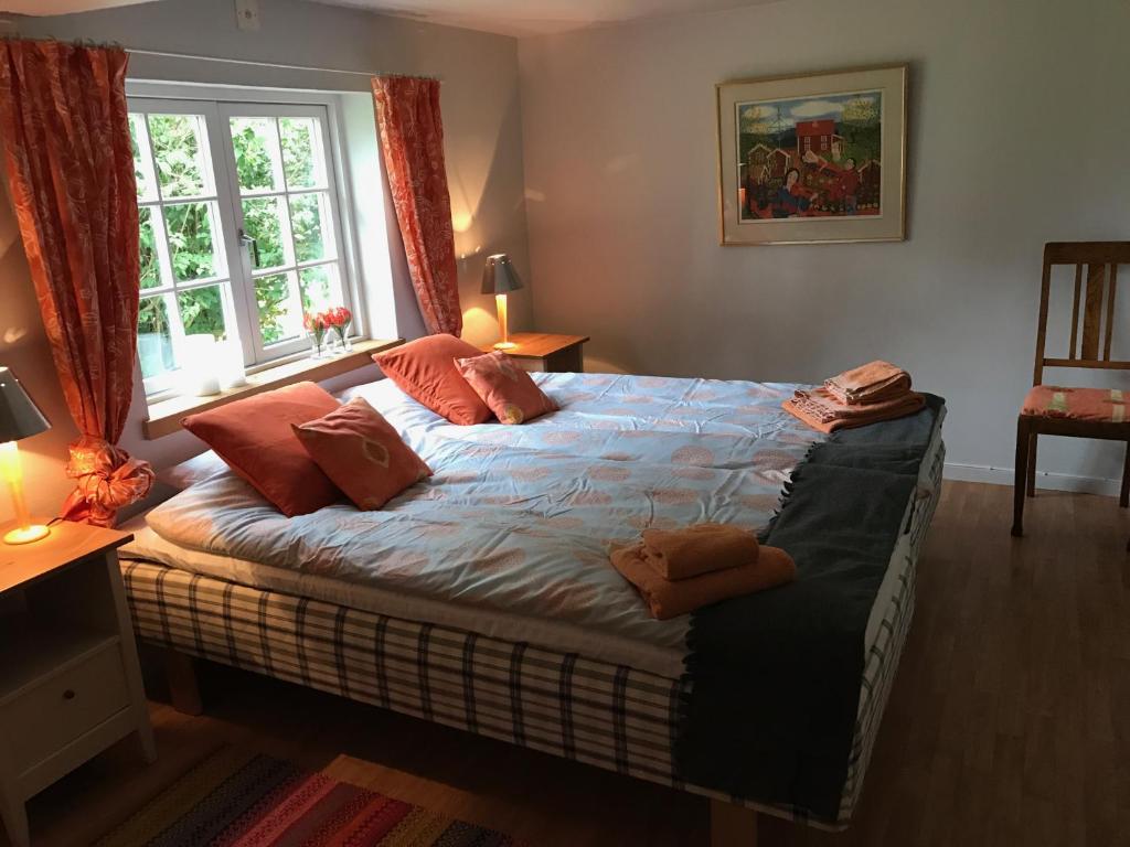 una camera da letto con letto, cuscini e finestra di Bed & Breakfast Höllviken a Höllviken
