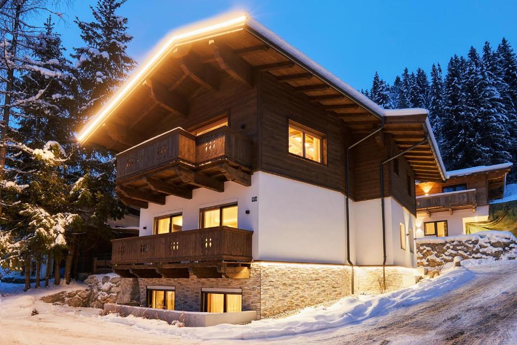 a house in the snow with the lights on at Top modernes Ferienhaus mit Sauna! Nicht weit vom Skilift in Kirchberg in Tirol