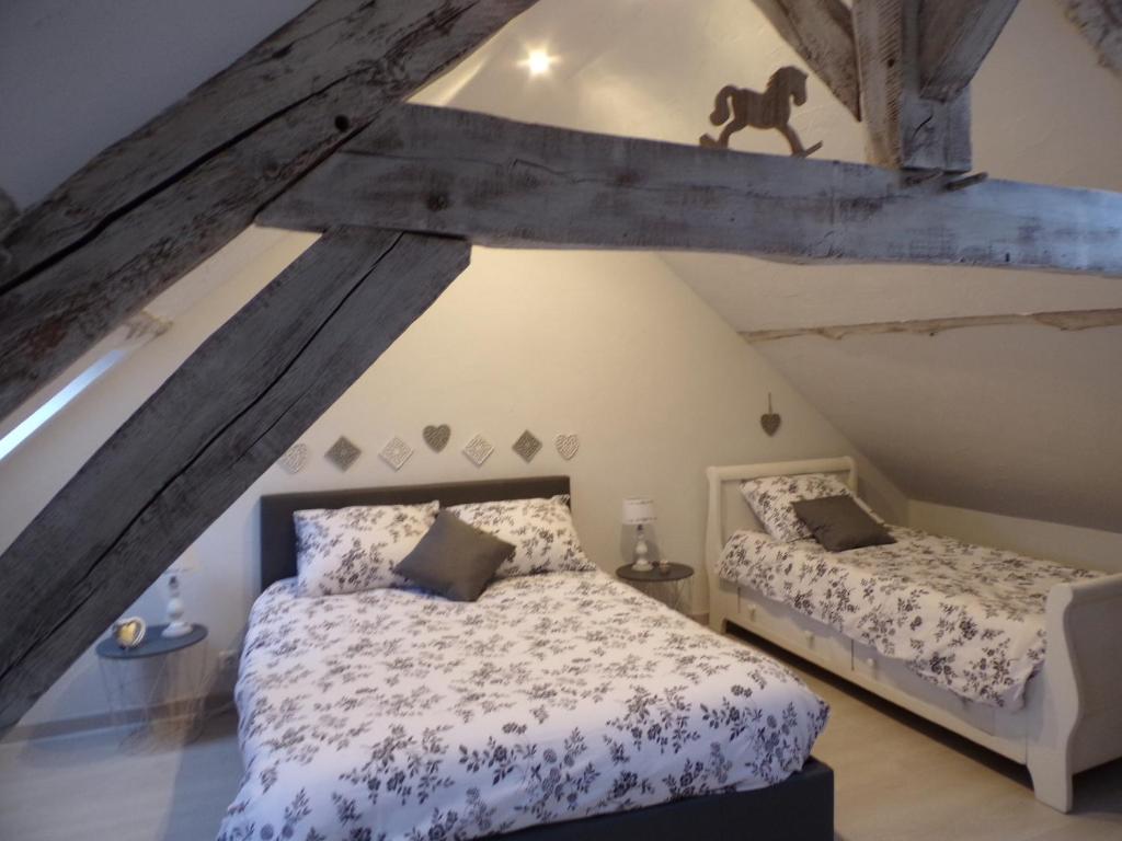 um quarto com 2 camas num sótão em les glycines em Cressonsacq
