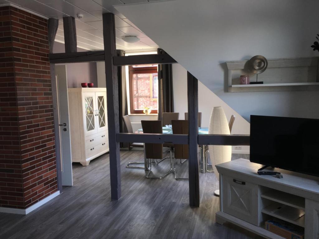 ein Wohnzimmer mit einer Treppe, einem Tisch und einem TV in der Unterkunft Harzer Ferienlodge in Wernigerode