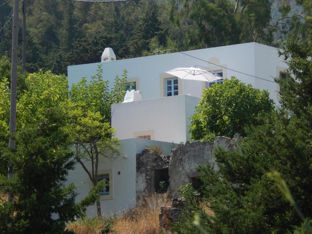 a white house on a hill with trees at Villa Kos in Asfendioú