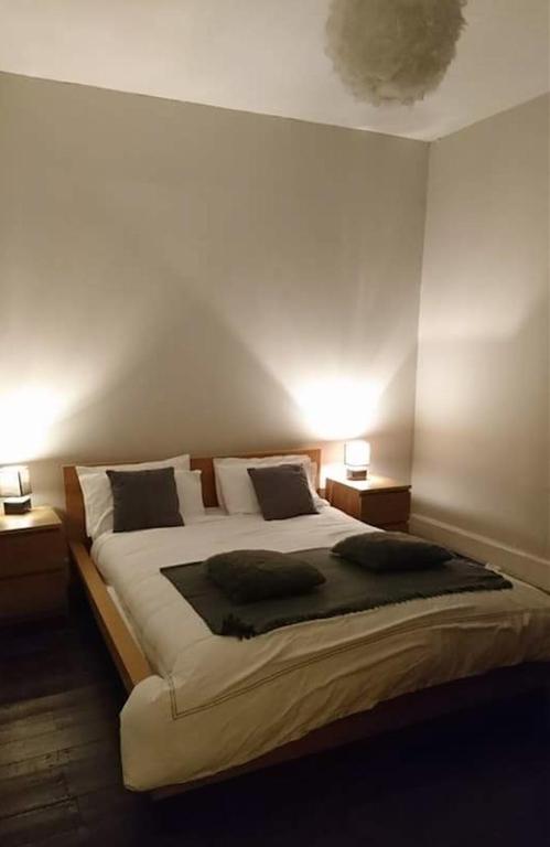 a bedroom with a large bed with two night stands at The Haven Cottage in Slamannan