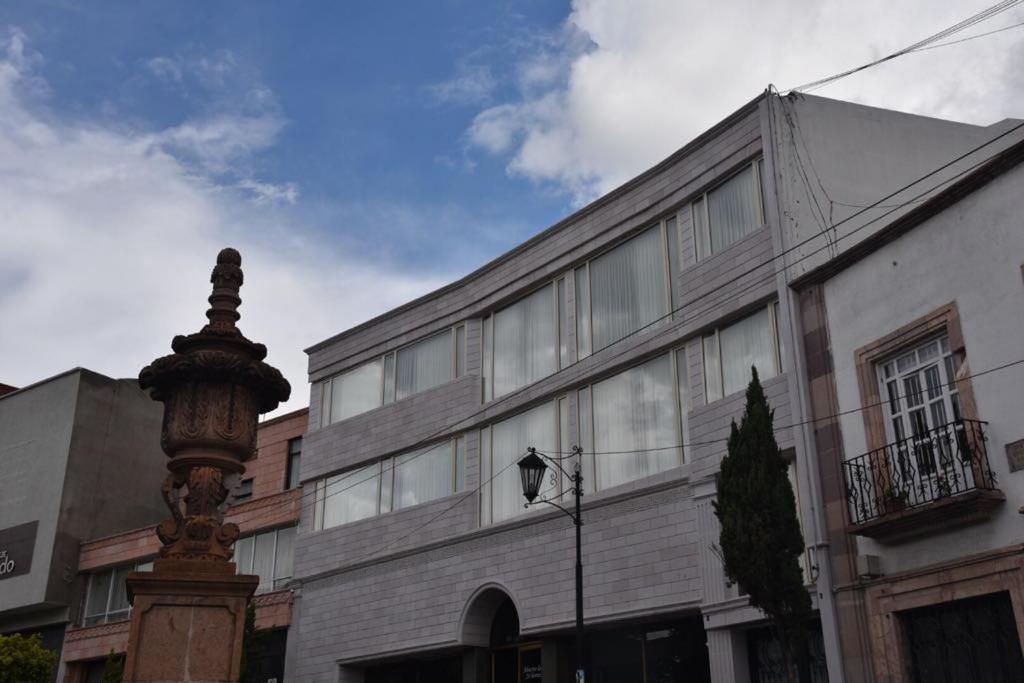 um edifício e uma luz de rua em frente a um edifício em Suites San Pedro em Zacatecas
