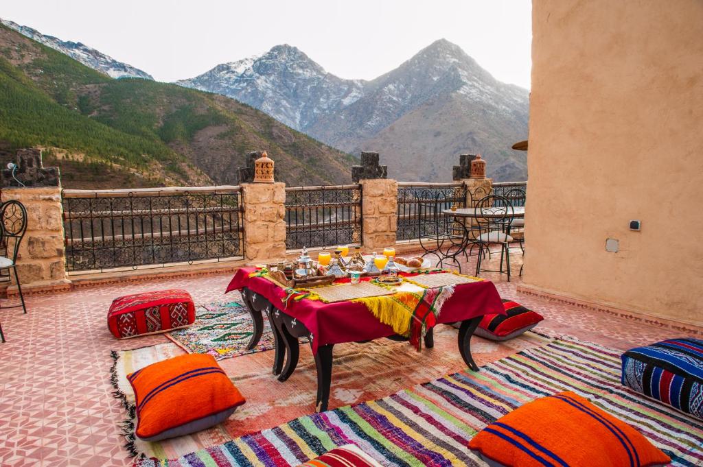 una mesa en un balcón con vistas a las montañas en Toubkal Ecolodge, en Imlil