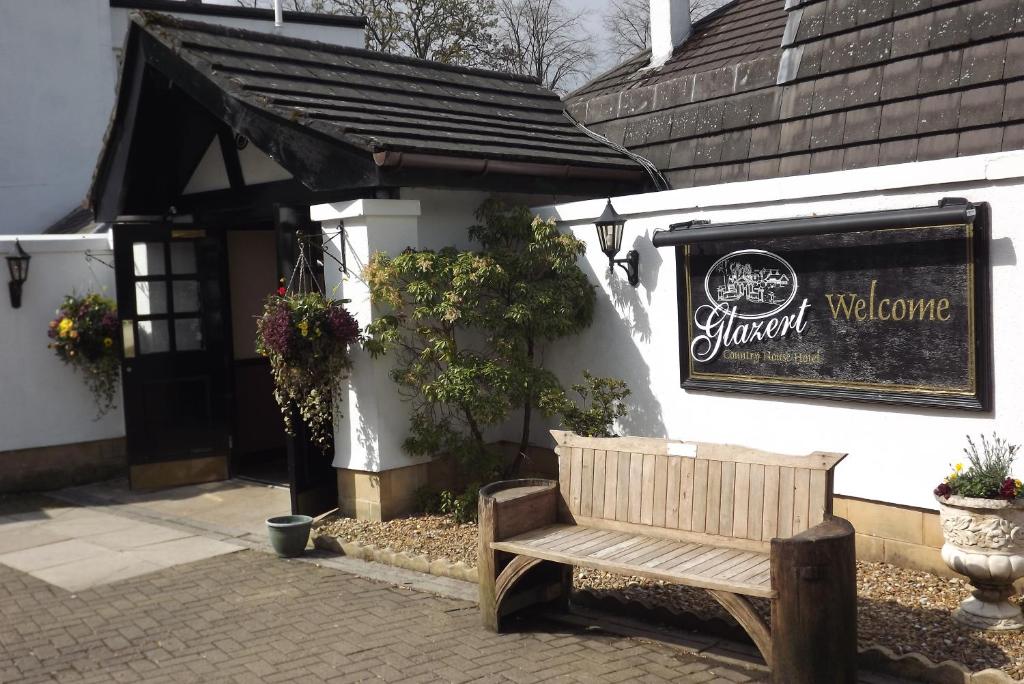 a wooden bench sitting outside of a building at Glazert Country House Hotel in Lennoxtown