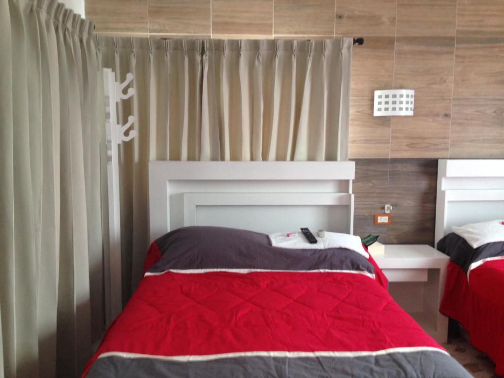 a bedroom with a bed with a red blanket at Hotel Claudia in Macuspana