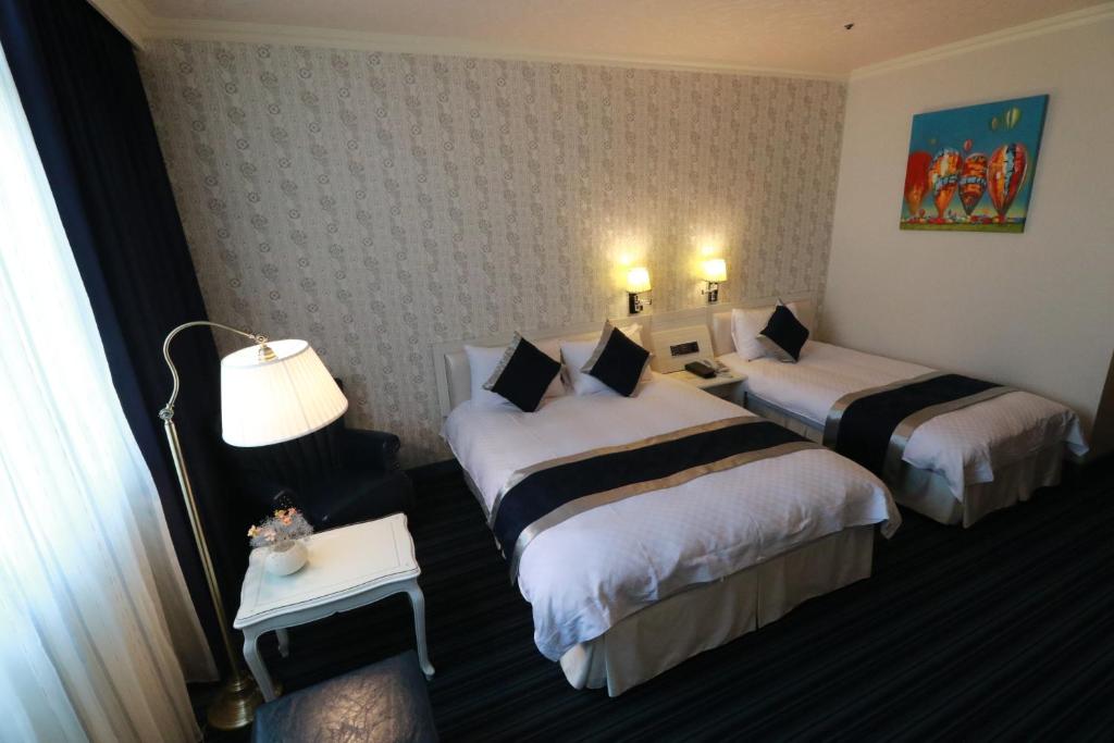 Postel nebo postele na pokoji v ubytování Hotel River Kinmen