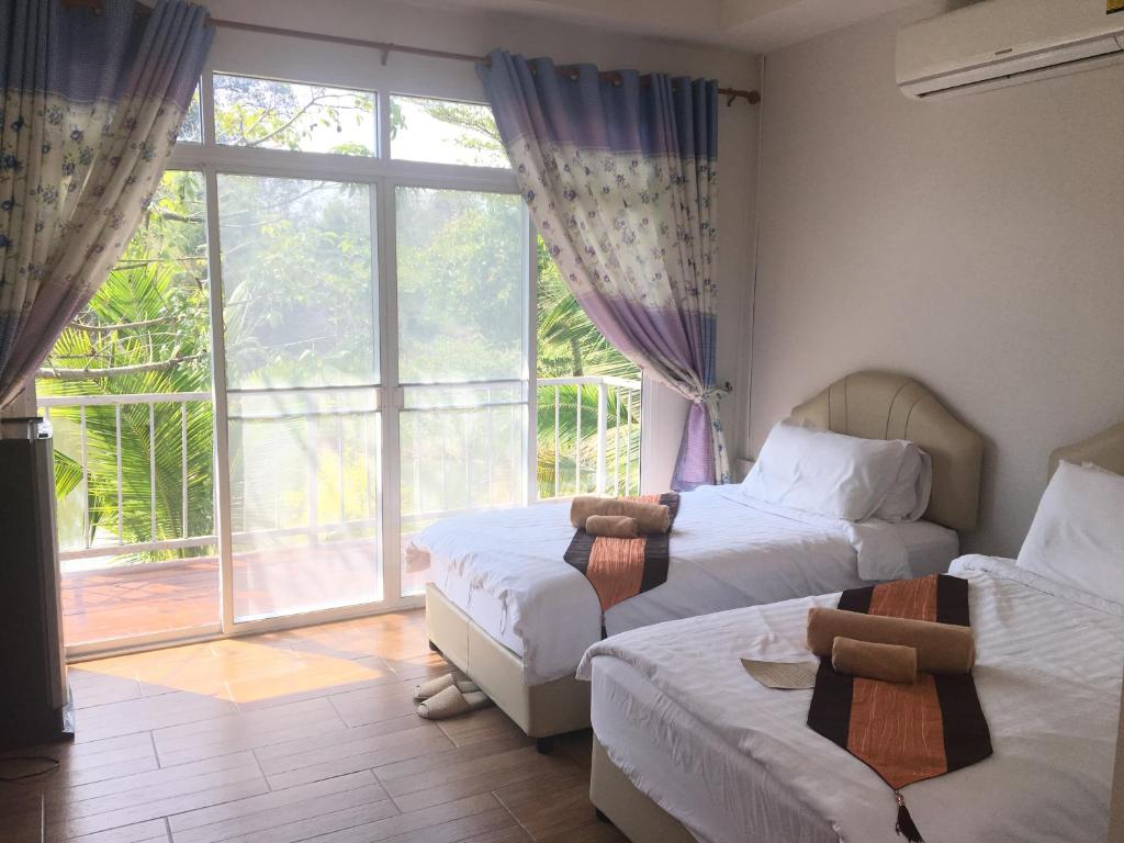 1 dormitorio con 2 camas y ventana grande en The Creek Villa, en Loei