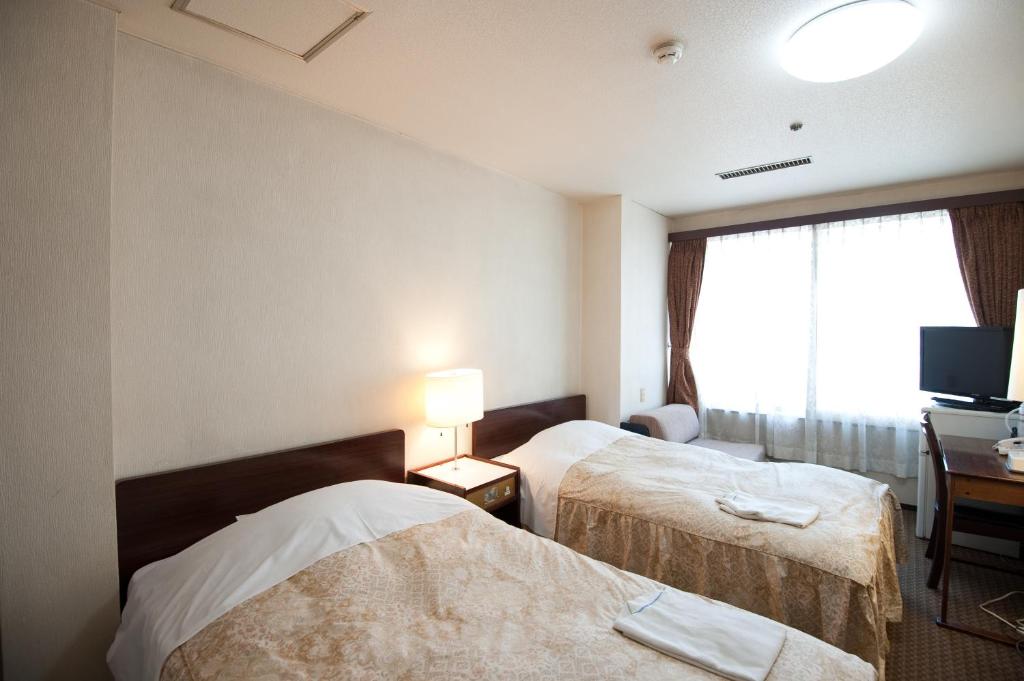 Postel nebo postele na pokoji v ubytování Ryogoku River Hotel