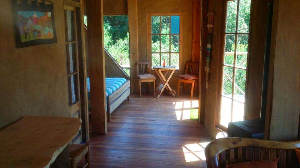 a hallway of a house with a bed and windows at Cabaña Cajón del Maipo in San José de Maipo