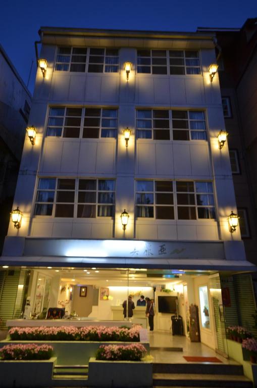 a large white building with flowers in front of it at Maria Hotel in Zhongzheng