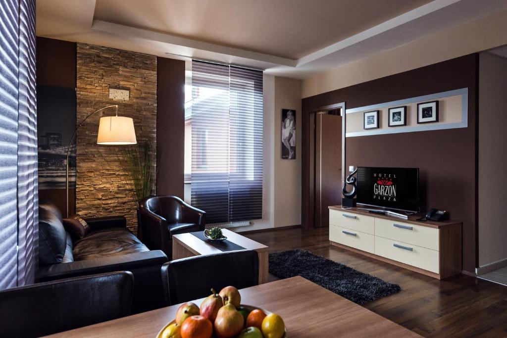 a living room filled with furniture and a tv at Hotel Garzon Plaza in Győr