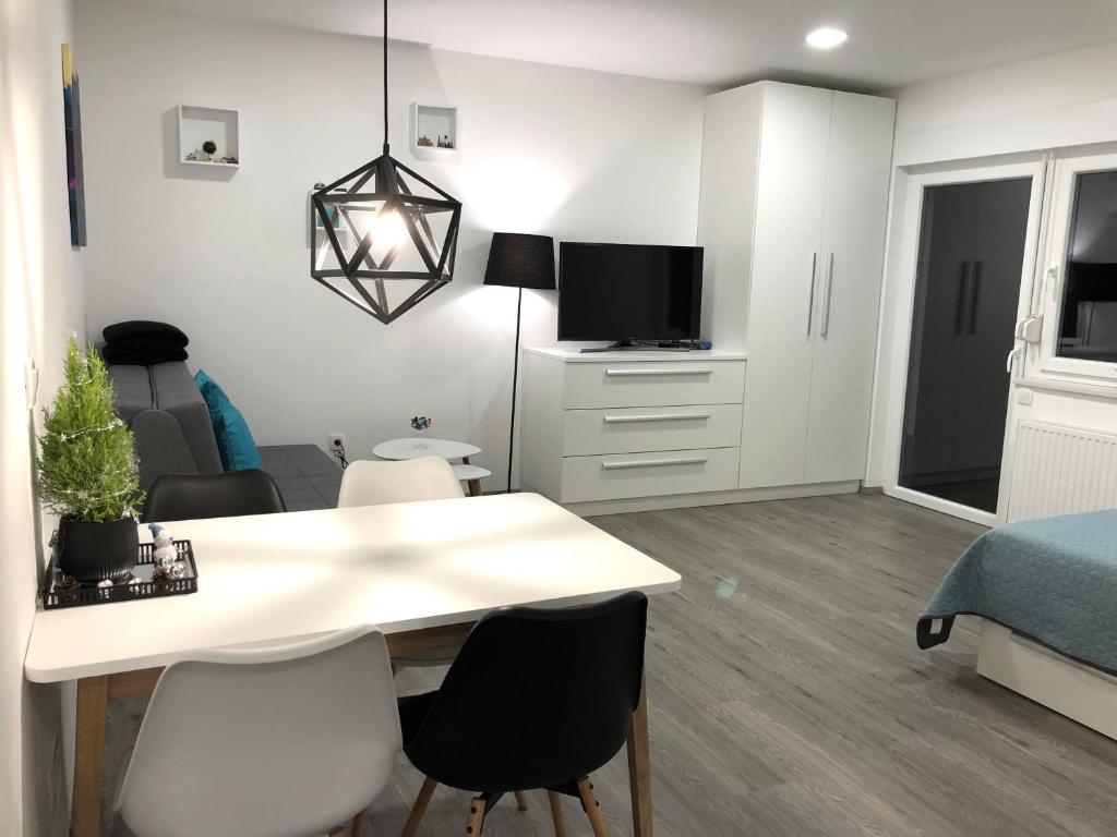a living room with a dining table and a bedroom at Luxury Studio Apartments in Ljubljana