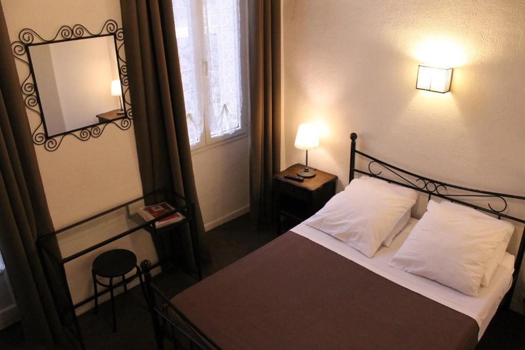 Postel nebo postele na pokoji v ubytování Nouvel Hotel