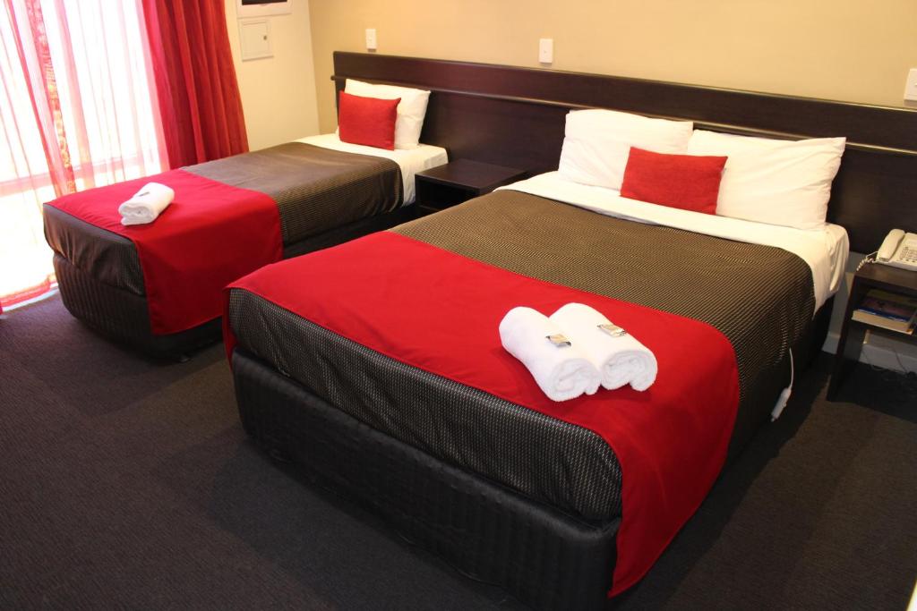 two beds in a hotel room with towels on them at Collie Ridge Resort in Collie