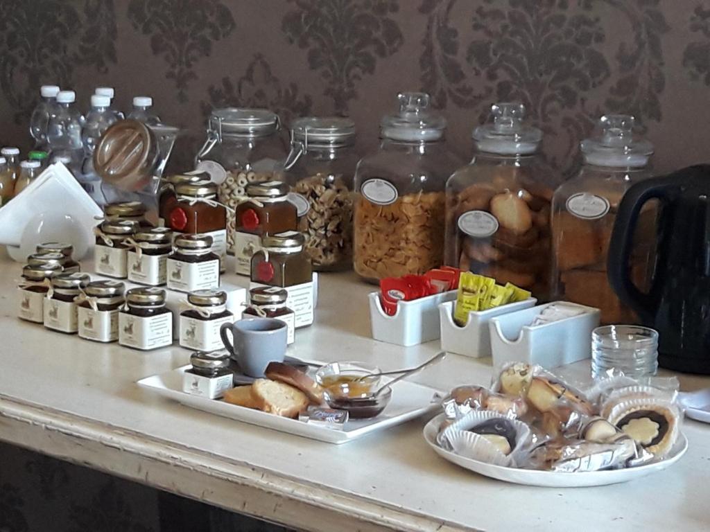a table with two plates of food and jars of food at B&B Del Piazzo in Biella