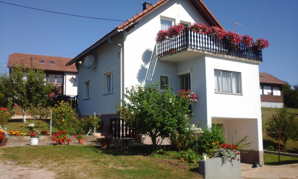 una casa blanca con flores en el balcón en Apartment Dolores en Smoljanac