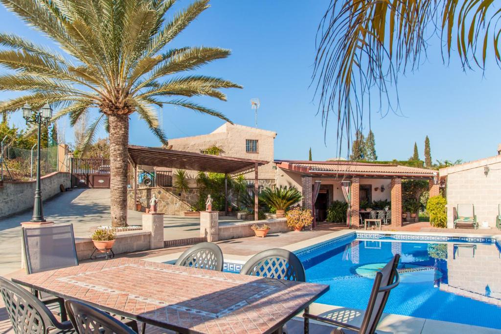 un patio con mesa y sillas junto a una piscina en Cubo's Finca Galiano, en Alhaurín el Grande