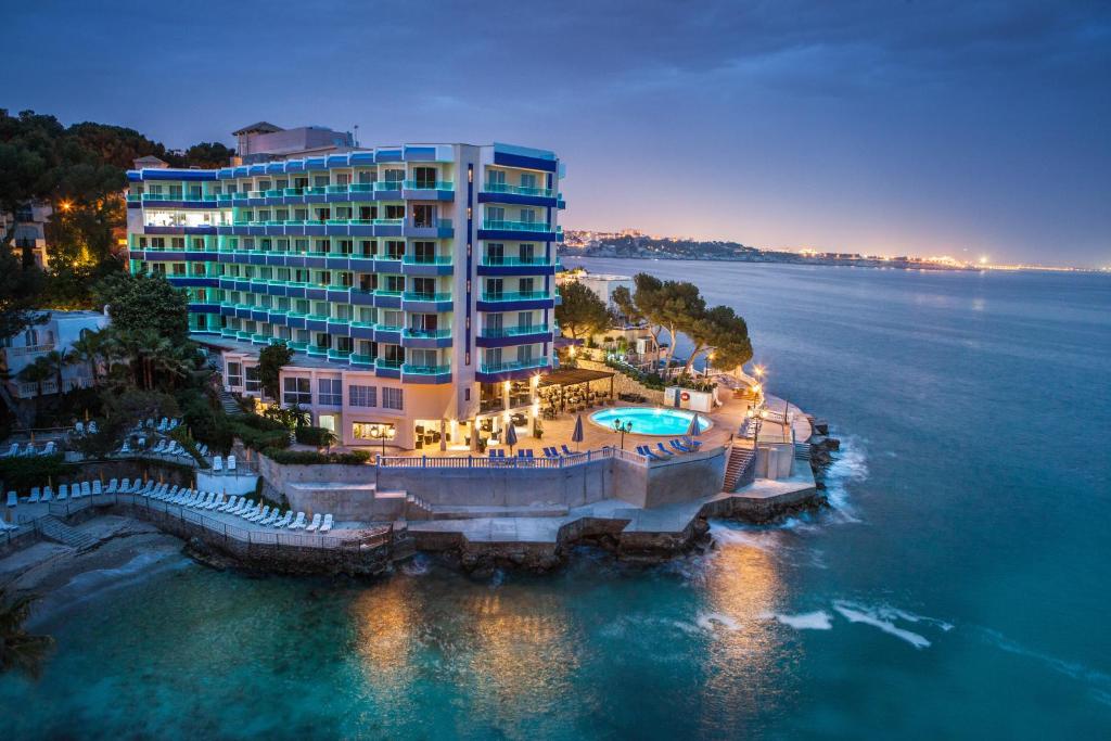 une vue aérienne d'un hôtel sur l'eau la nuit dans l'établissement Europe Playa Marina - Adults Only, à Illetas
