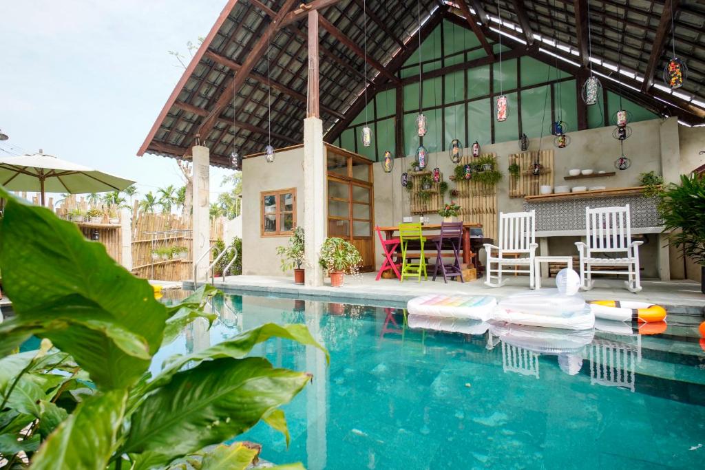 une piscine avec deux chaises et une maison dans l'établissement HA Devan Hoian Pool Villa, à Hội An