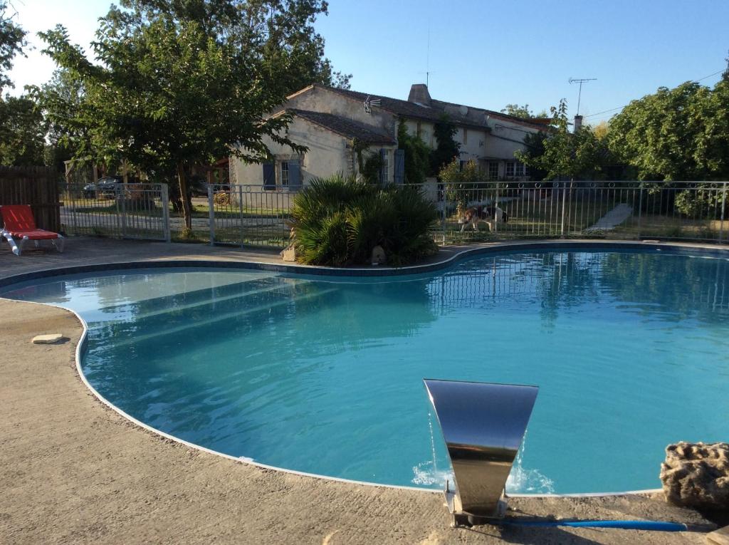 - une piscine avec une chaise dans la cour dans l'établissement La Ferme de Fossillon, à Marans