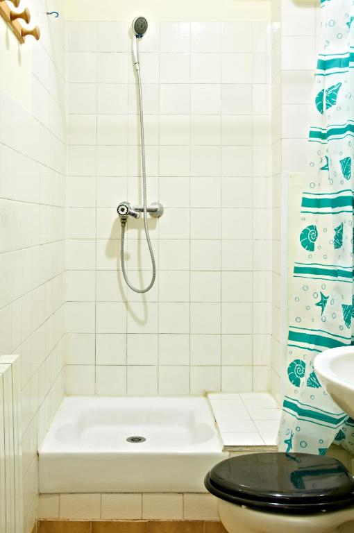 a bathroom with a shower with a toilet and a sink at Hotel Luxor in Issy-les-Moulineaux