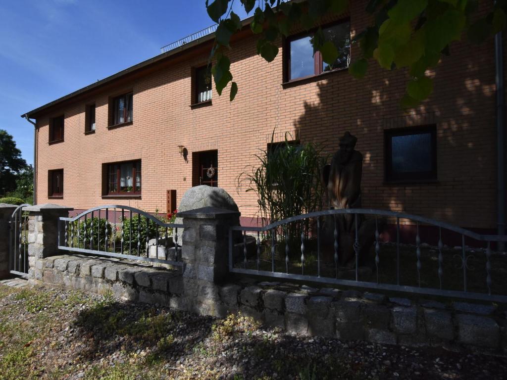 a fence in front of a brick building at Comfortable Apartment in Zweedorf with Barbecue in Zweedorf