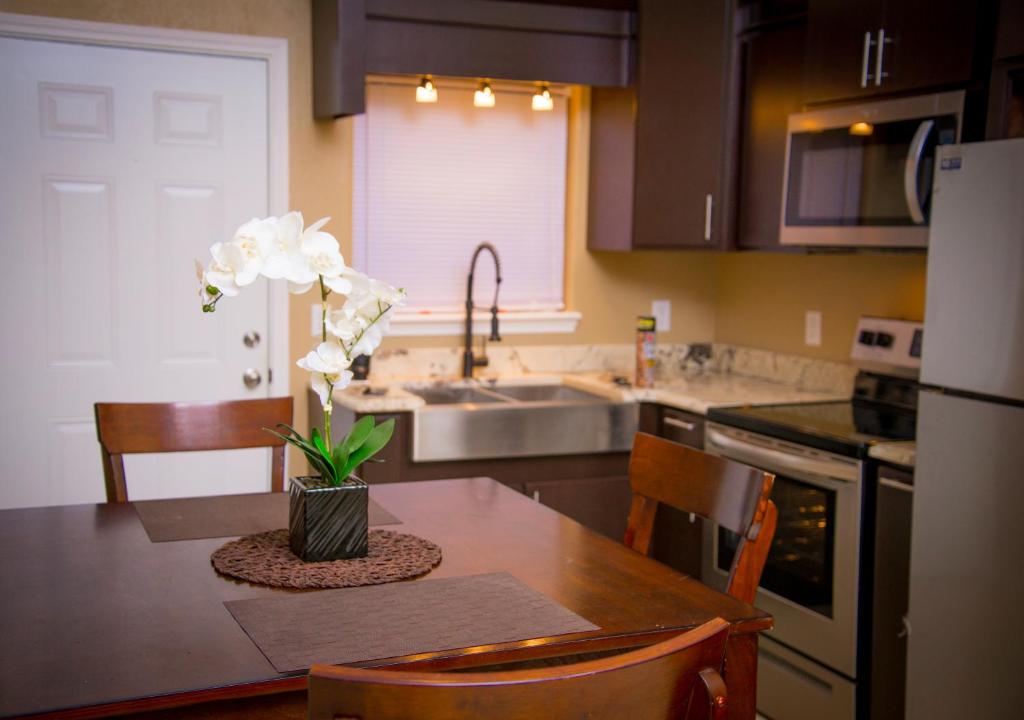 una cocina con una mesa con un jarrón de flores. en Casino Casita en Eagle Pass