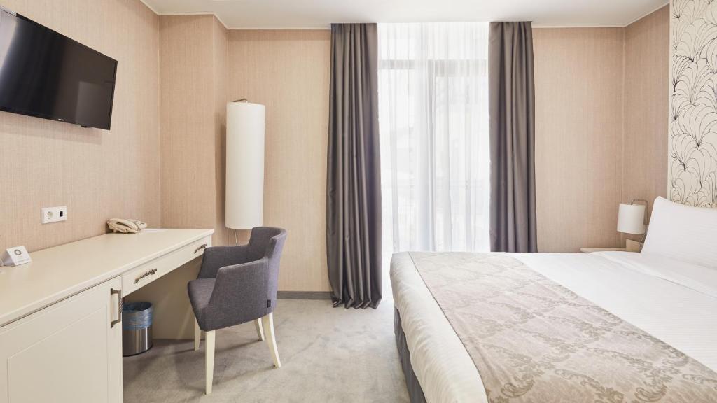 Postel nebo postele na pokoji v ubytování Gallery Palace Hotel