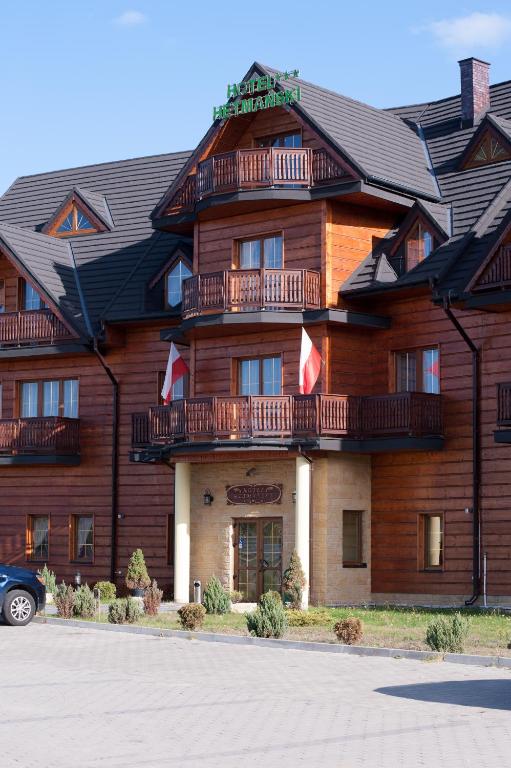 un grand bâtiment en bois avec des balcons dans l'établissement Hotel Hetmański, à Rawa Mazowiecka