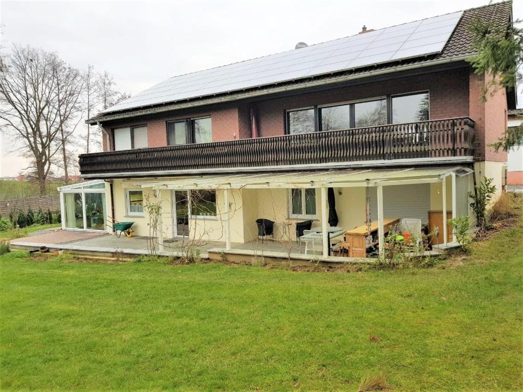 ein großes Haus mit einer Veranda und einer Liegewiese in der Unterkunft Ferienwohnung Rosita in Langgöns