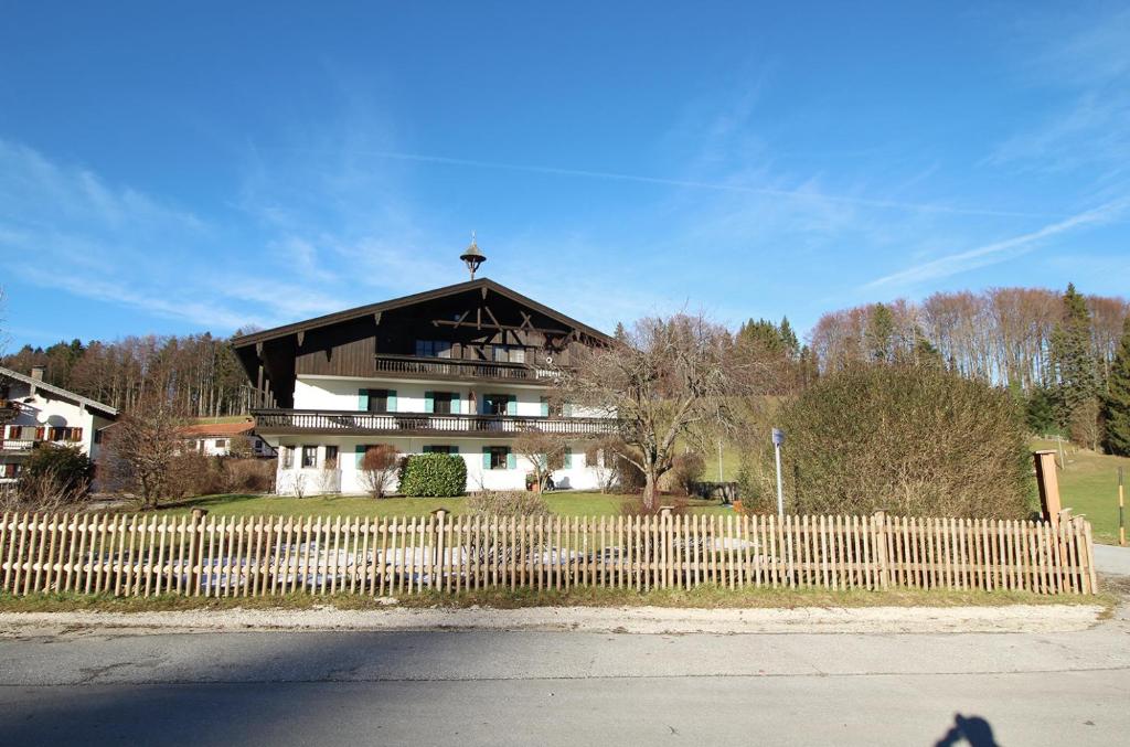 ein Haus mit einem Holzzaun davor in der Unterkunft Gschwendtnerhof in Aschau im Chiemgau