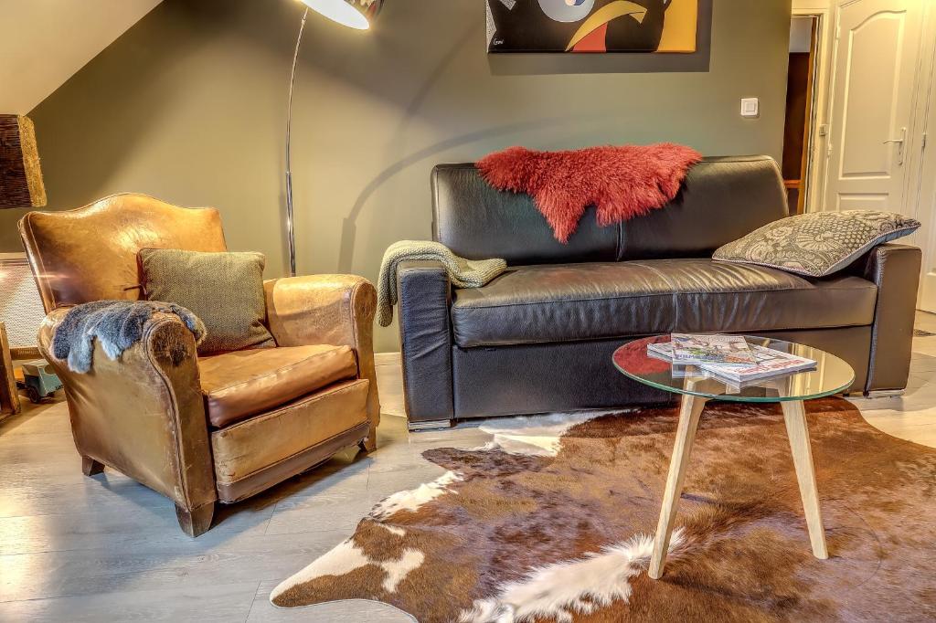 sala de estar con sofá de cuero y 2 sillas en Gite "le millésime", en Épernay