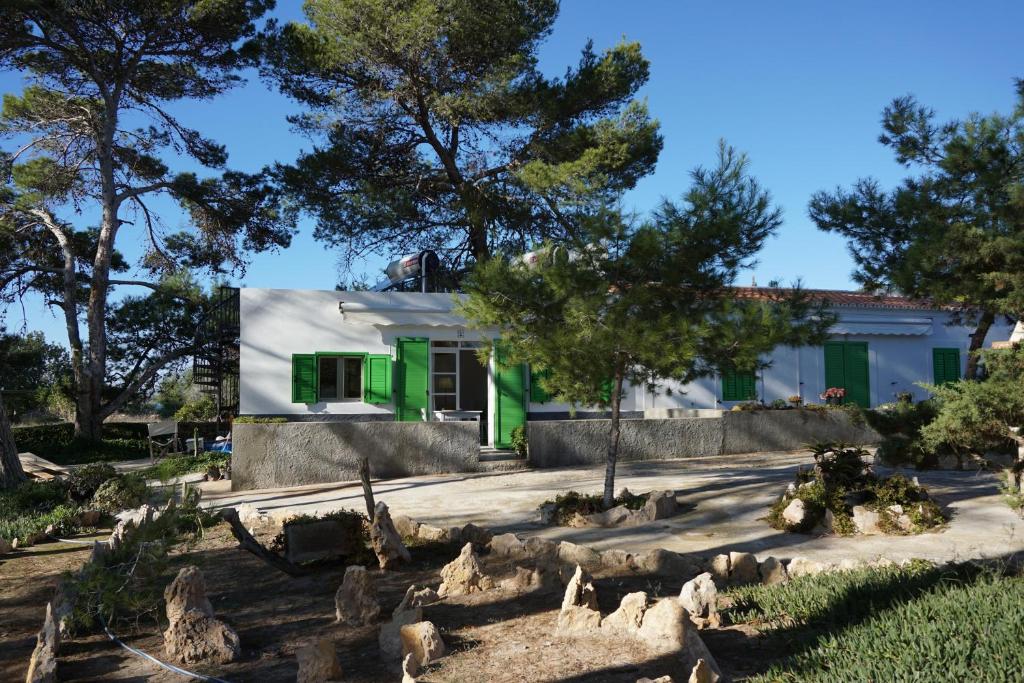 una casa con una puerta verde y algunos árboles en Bungalows del Lago - Astbury Formentera en La Savina