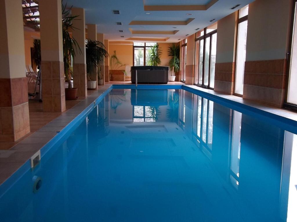 a swimming pool with blue water in a building at Dorina wellness in Siófok