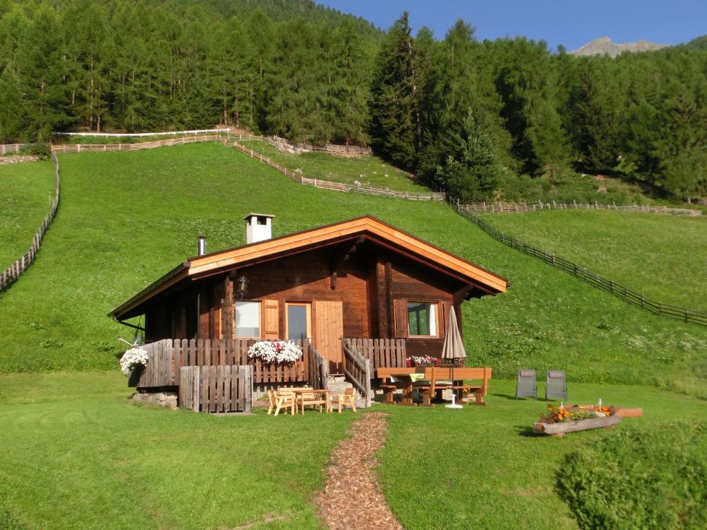 a cabin on a hill with a table and chairs at Ferienhütte Premstlahof in Martello