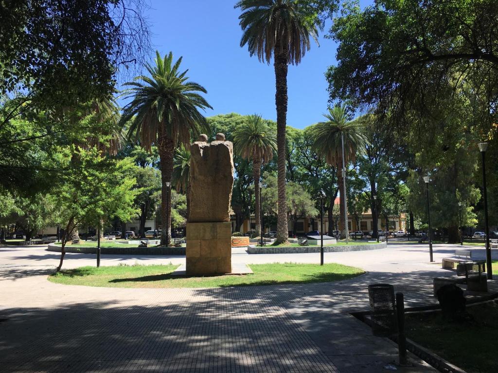 a statue in the middle of a park with palm trees at Apartamento Gutierrez in Mendoza