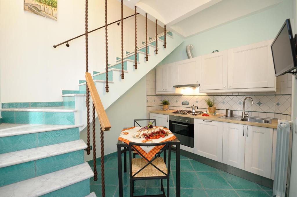 アマルフィにあるDomus Florio Sabbiaの白いキャビネット、テーブル、階段付きのキッチン