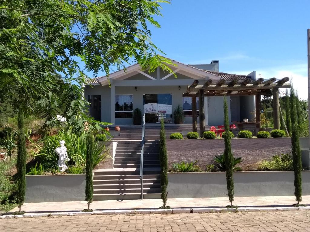 a house with a wooden pergola in front of it at Pousada Vó Santina in Protásio Alves