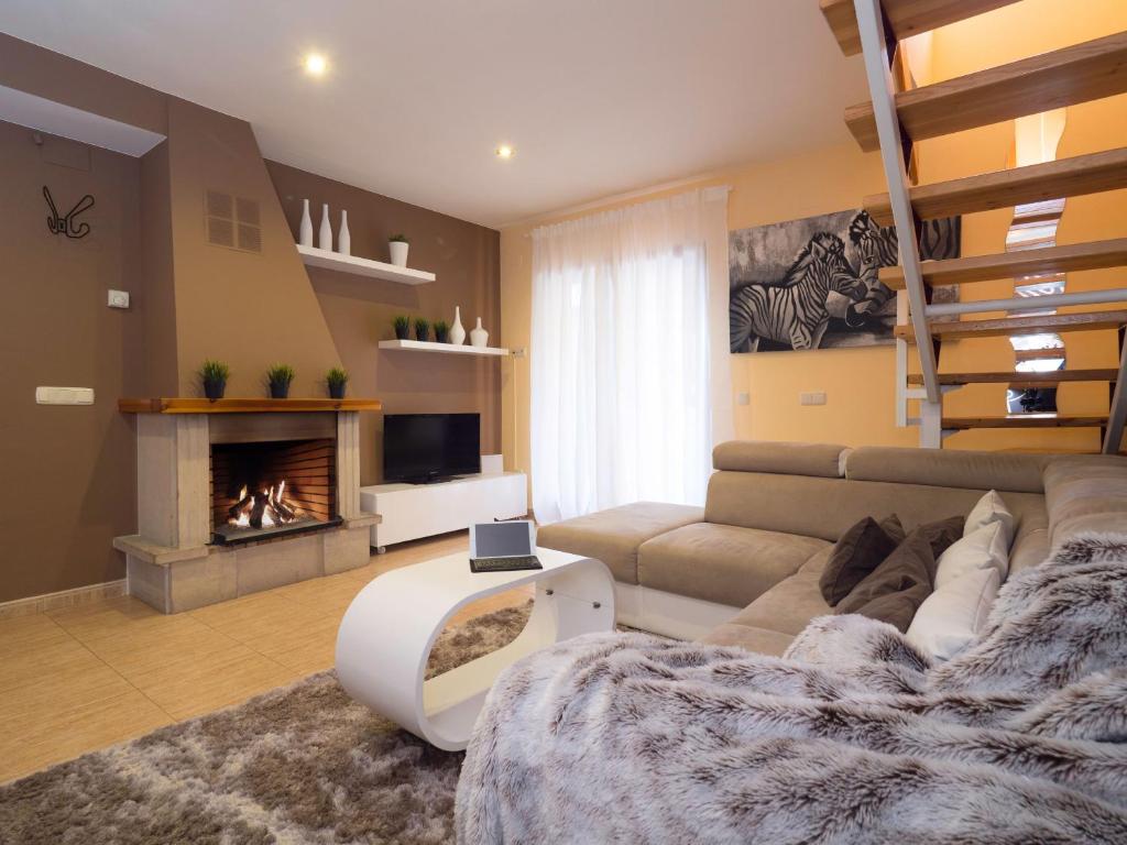 een woonkamer met een bank en een open haard bij El Despertar in Boltaña