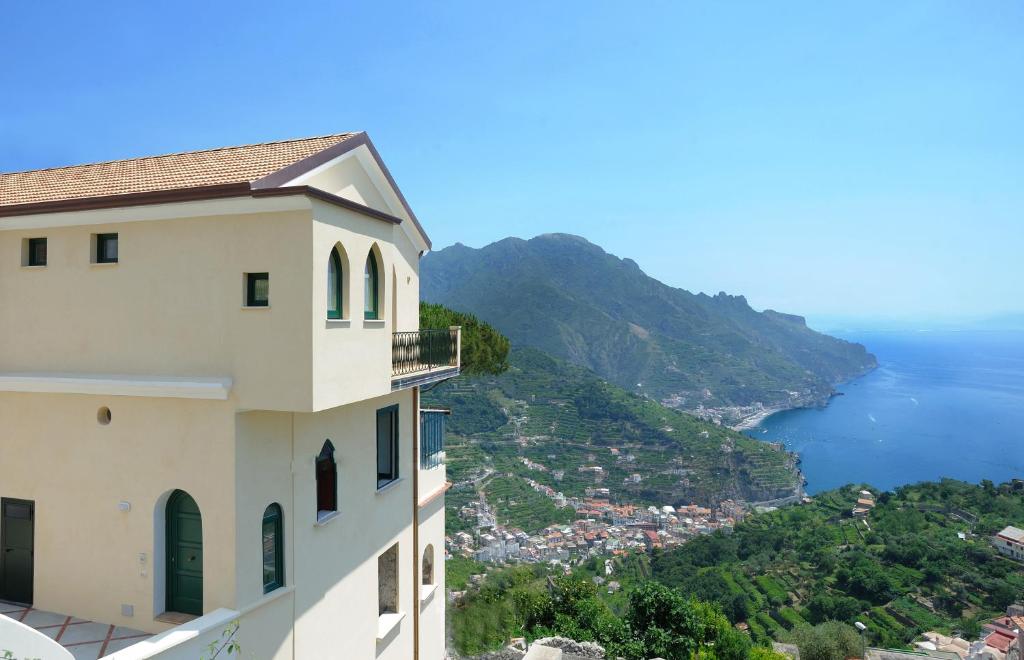een uitzicht op de kust van Amalfi vanuit een gebouw bij La Dolce Vita Ravello in Ravello