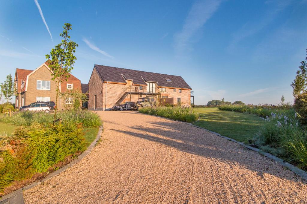 une maison avec une route en gravier devant elle dans l'établissement Eyndevelde, à Herzele