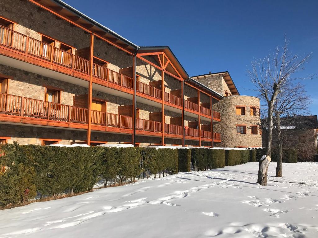 a building with snow in front of it at Font Romeu Via (Maison du Soleil) in Font-Romeu-Odeillo-Via