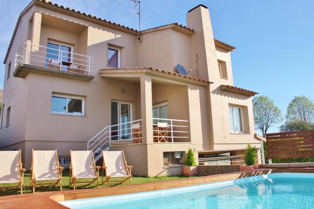 eine Villa mit einem Pool vor einem Haus in der Unterkunft casa santa caterina in Torroella de Montgrí