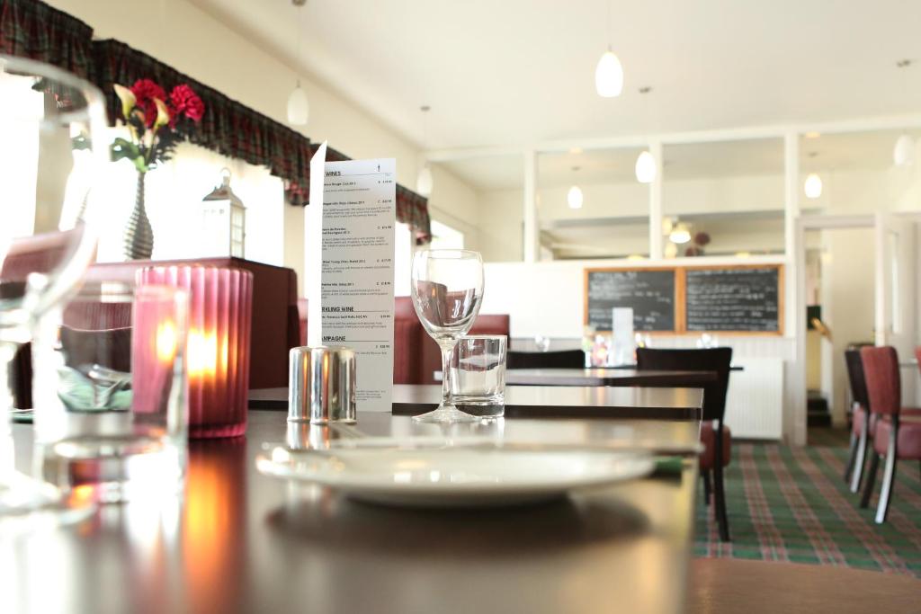 un restaurante con una mesa con dos vasos. en Station Hotel Portsoy, en Portsoy