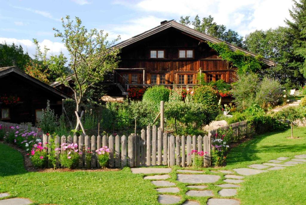 une maison en bois avec une clôture et un jardin dans l'établissement Chalet des Fermes de Marie, avec services, Collection Chalets des Fermes, à Megève