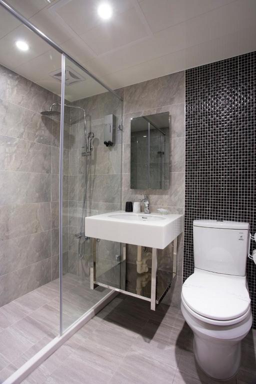 a bathroom with a toilet and a sink and a shower at Rainbow Hotel in Taipei