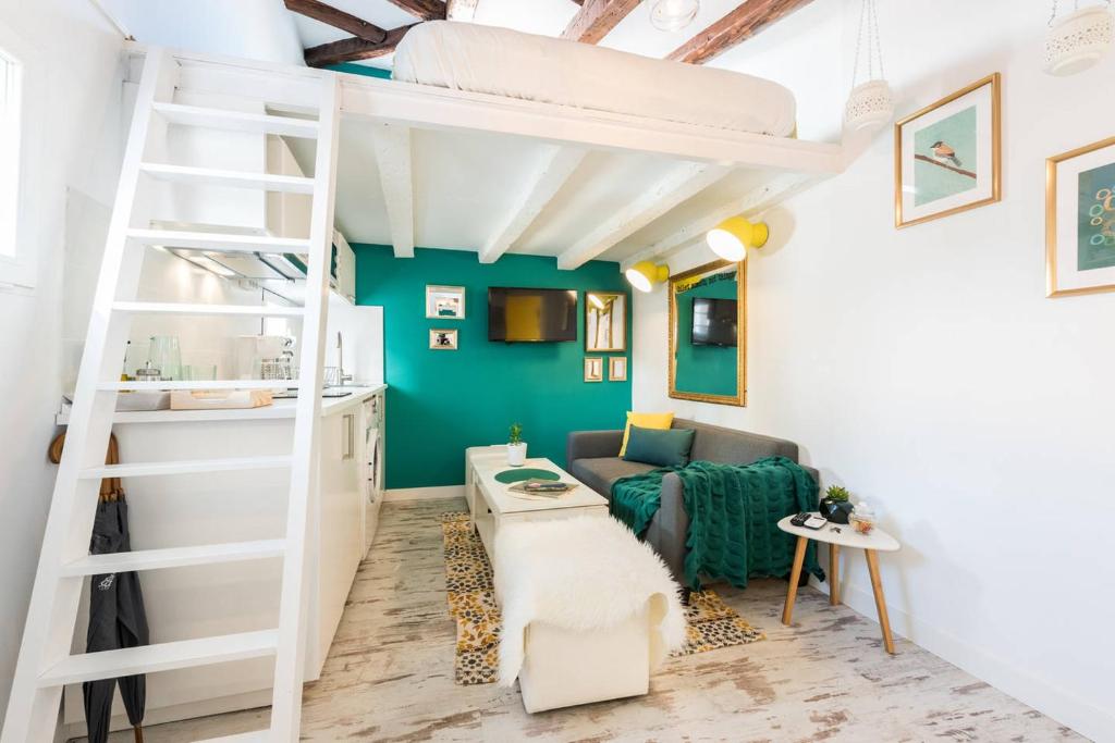 マドリードにあるBuhardilla en Calle Amparo-Lavapiésのロフトベッド1台とソファが備わる客室です。